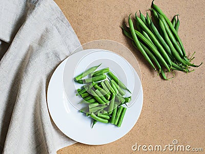 Sliced green beans on a white plate and a bunch of green beans Stock Photo