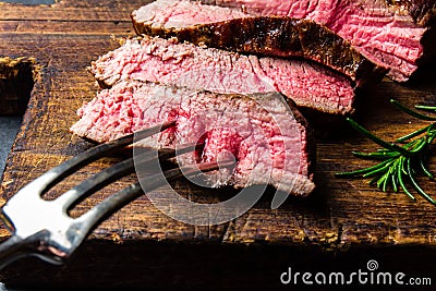 Sliced grilled medium rare beef steak served on wooden board Barbecue, bbq meat beef tenderloin. Top view, slate Stock Photo