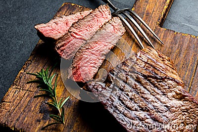 Sliced grilled medium rare beef steak served on wooden board Barbecue, bbq meat beef tenderloin. Top view, slate background Stock Photo