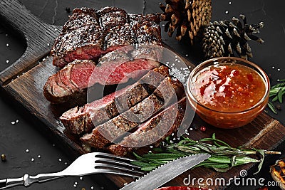 Sliced grilled medium rare beef steak served on wooden board Barbecue, bbq meat beef tenderloin. Stock Photo