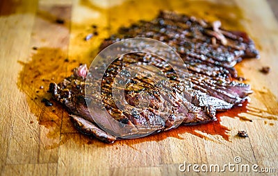 Sliced grilled juicy marinated beef flank steak on wooden board Stock Photo