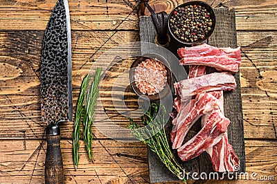Sliced lamb short spare loin ribs, raw meat on a wooden cutting board. Wooden background. Top view Stock Photo