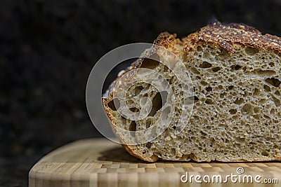Sliced loaf of artisanal whole wheat and dark rye rustic sourdough bread on a cutting board, baked at home, photo series Stock Photo