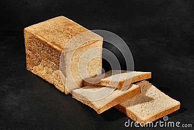 Sliced loaf of fresh, palatable baked white bread against black background with copy space. Close-up Stock Photo