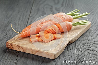 Sliced organic carrot on olive wood cutting board Stock Photo