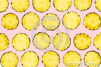 Sliced pineapple pieces lay in pattern on isolated light pink ba Stock Photo