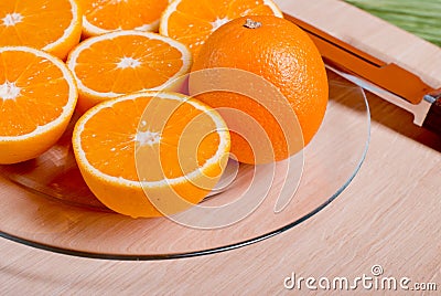 sliced ripe appetizing orange on a cutting board on a green table Stock Photo