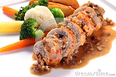 Sliced roasted boneless chicken breast with mushroom sauce on white plate Stock Photo