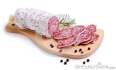 Sliced salami on wooden cutting board isolated on white background. Stock Photo