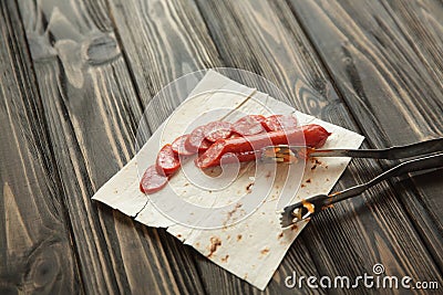 Sliced salami on pita bread on wooden background Stock Photo