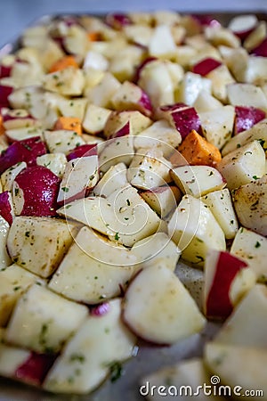 Sliced and seasoned potatoes ready for roasting Stock Photo