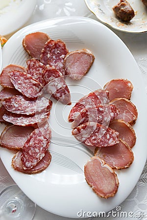 Sliced smoked sausage on a plate. Smoked sausage sliced on a white plate, homemade table Stock Photo