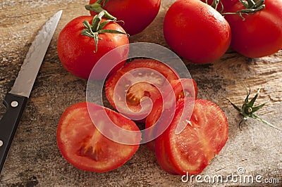 Sliced succulent red tomatoes beside serrated knife Stock Photo