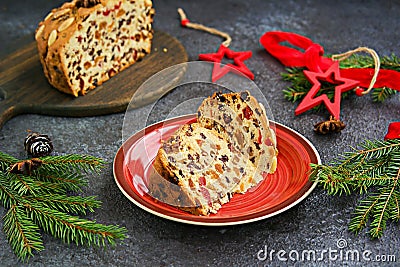 Sliced traditional Scottish Christmas Dundee fruit cake with dried fruit mix, garnished with peeled almonds on a red plate against Stock Photo