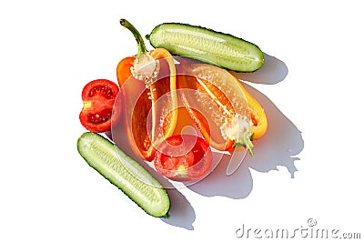 Sliced Vegetables Cucumbers, Bell Peppers and Tomatos red green yellow orange in water drops on white background Isolated top view Stock Photo