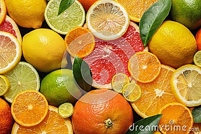 Sliced and whole citrus fruits with leaves as background Stock Photo