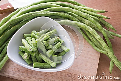 Sliced yard long bean vegetable on the white dish and wooden block. Stock Photo