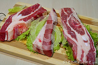 Slices of beef on a wooden board on the table. Stock Photo
