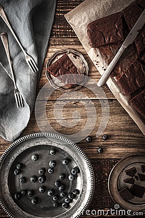 Slices of chocolate brownie with blueberry and vintage dinnerware vertical Stock Photo
