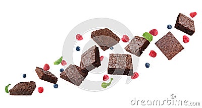 Slices of delicious chocolate brownie with fresh berries and mint flying on white background. Banner design Stock Photo