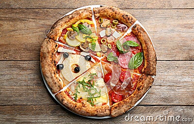 Slices of different pizzas on wooden table Stock Photo