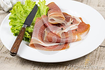 Slices of dry ham on a plate Stock Photo