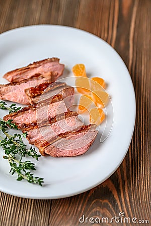 Slices of duck breast with fresh thyme Stock Photo