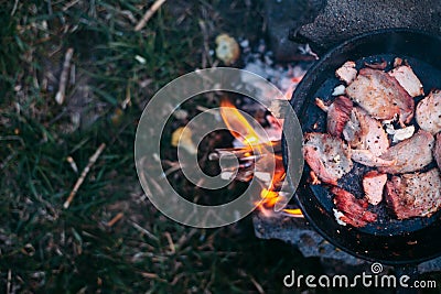Slices of fried bacon in a pan. Food in a forest camp. Cooking on fire. Picnic in the nature. Grilled food on nature Stock Photo
