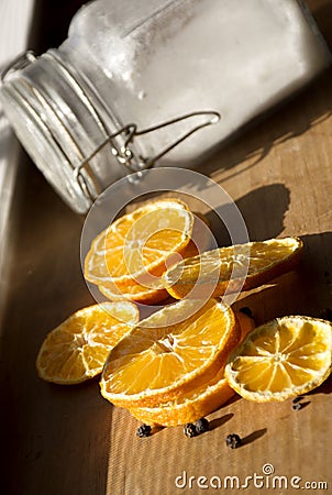 Slices oranges, glass jar with sugar inside, day light shot. Selective focus Stock Photo