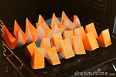 Slices pumpkin on a baking sheet in the oven Stock Photo