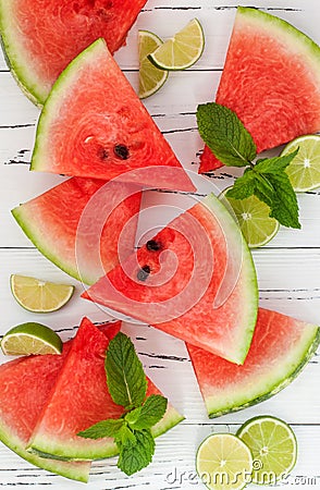 Slices of ripe juicy organic watermelon on old wooden table, served with fresh lime and mint leaves. Watermelon mojito ingredients Stock Photo