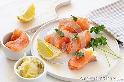 Slices of salmon wrapped with cottage cheese and marinated ginger. Party snack Stock Photo