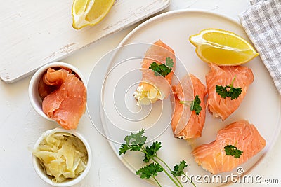 Slices of salmon wrapped with cottage cheese and marinated ginger. Party snack Stock Photo