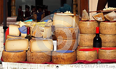 Slices and wheels of Pecorino cheese together with bottles of Cannonau, white wine, pasta and other Sardinian typical dishes Stock Photo