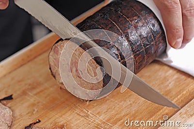 Slicing a chitterlings sausage Stock Photo