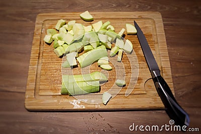 A slicing cucumber cut on a wooden cutting board and a knife Stock Photo
