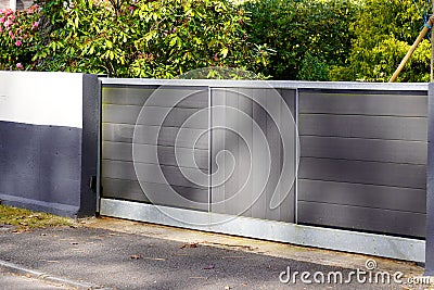 Sliding portal grey aluminum and wooden door home gate of suburbs house in city Stock Photo