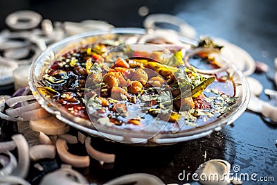 Slightly high angle shot of a glass plate full of Chole bhature in it on a black background along with some phudina/mint chutney a Stock Photo