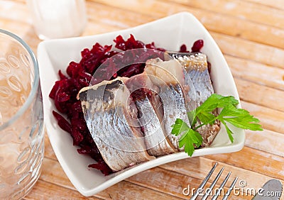 Slightly salted herring slices with grated beets and greens Stock Photo