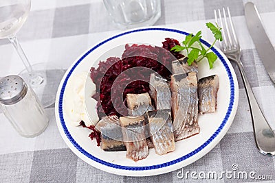 Slightly salted herring slices with grated beets and greens Stock Photo