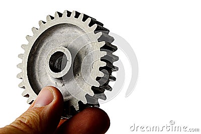 Slightly used alluminium alloy cog wheel from spur gear held in left hand on white background Stock Photo
