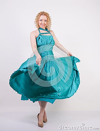 Slim airy girl in flying blue evening dress on white background in Studio Stock Photo