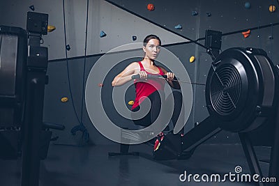 Slim fit muscular brunette woman exercise in gym, lifting weights and doing pilates. Picture with dark evening mood and film color Stock Photo