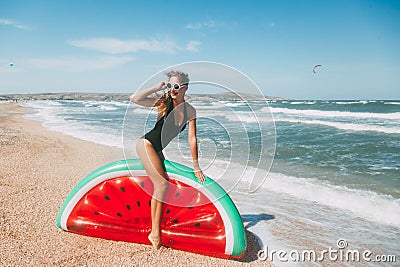 Slim girl playing with inflatable watermelon at sand beach Stock Photo