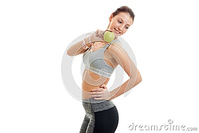 Slim girl in fitness grey top with Green Apple keeps a hand on the side Stock Photo