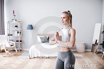 Slim girl practicing yoga at home, wellness, wellbeing Stock Photo