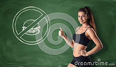 Slim girl showing thumb up on background with fast food warning label. Stock Photo