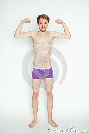 Slim man showing muscles Stock Photo