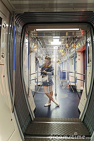 Slim teen girl in denim clothes rides the subway Stock Photo
