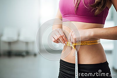 Slim woman measuring her thin waist Stock Photo